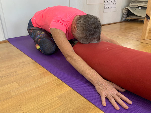 Forward Virasana pose with head support