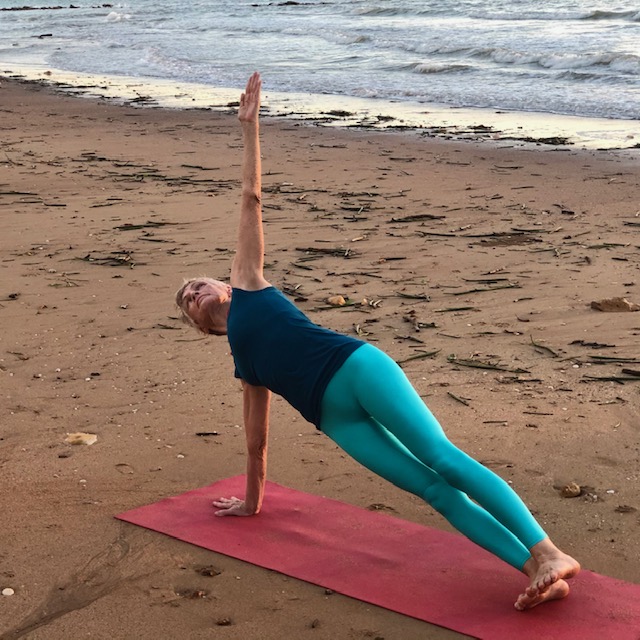 Side Plank, Vasisthasana, on the beach, a long-lever yoga pose for core strength