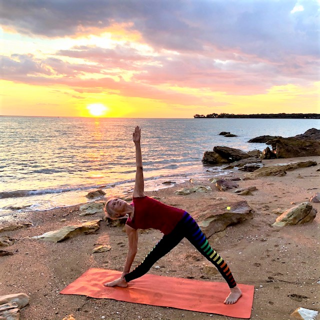 How long to hold yoga poses: Chris Lalor in Triangle Pose at sunset on a Darwin beach