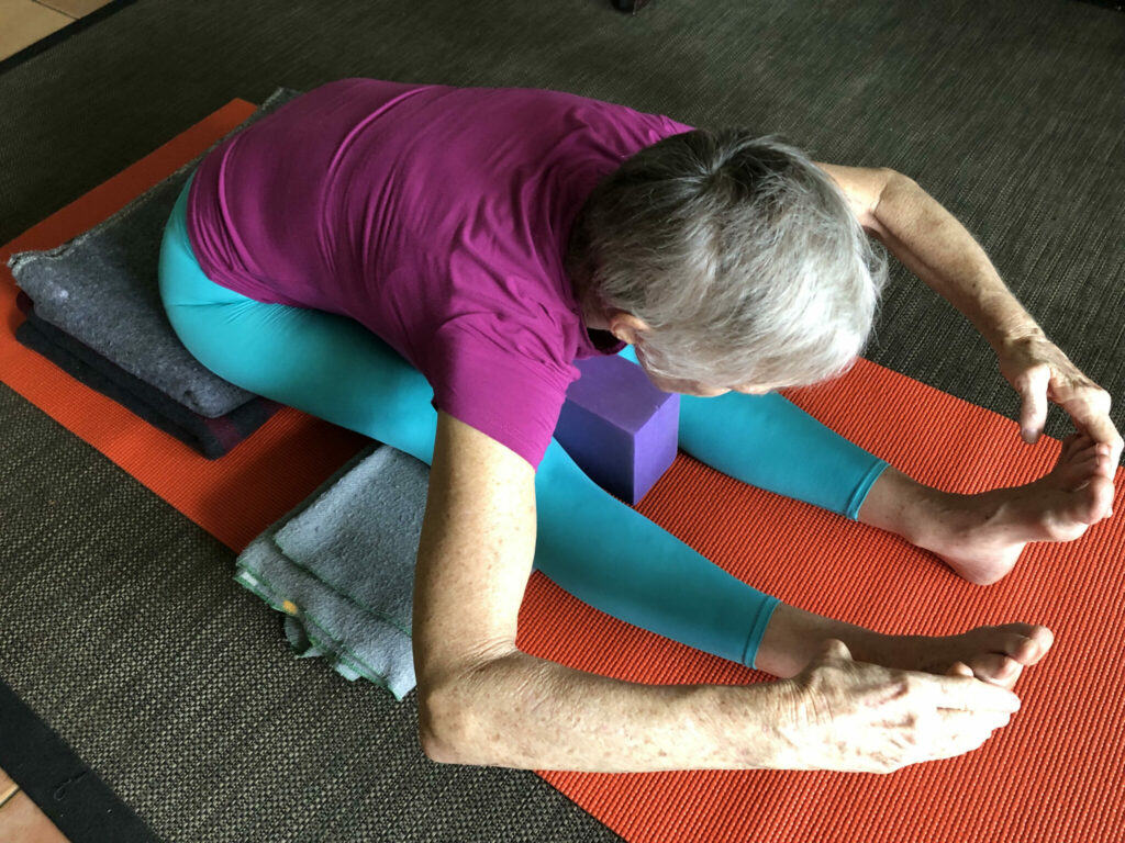 Chris in a head to knee forward bend with the leg straight