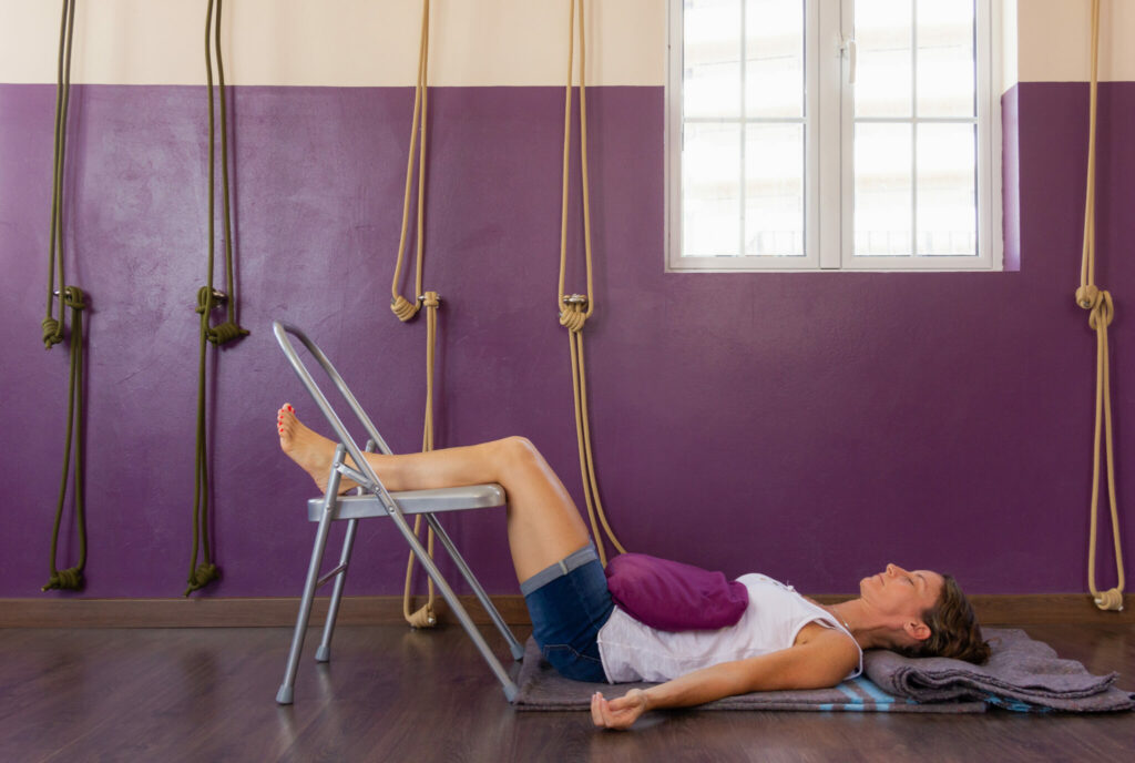 Yoga for sciatica: lying on the back with the lower legs resting on a chair seat