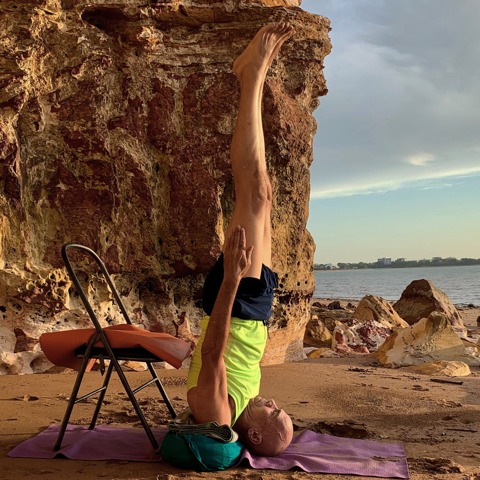 How long to build a yoga habit: Stuart McGill in a chair-supported shoulderstand on a Darwin beach