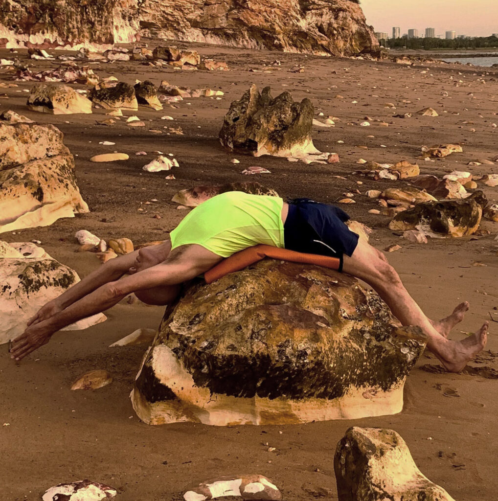 Stuart in a supported backbend over a rock