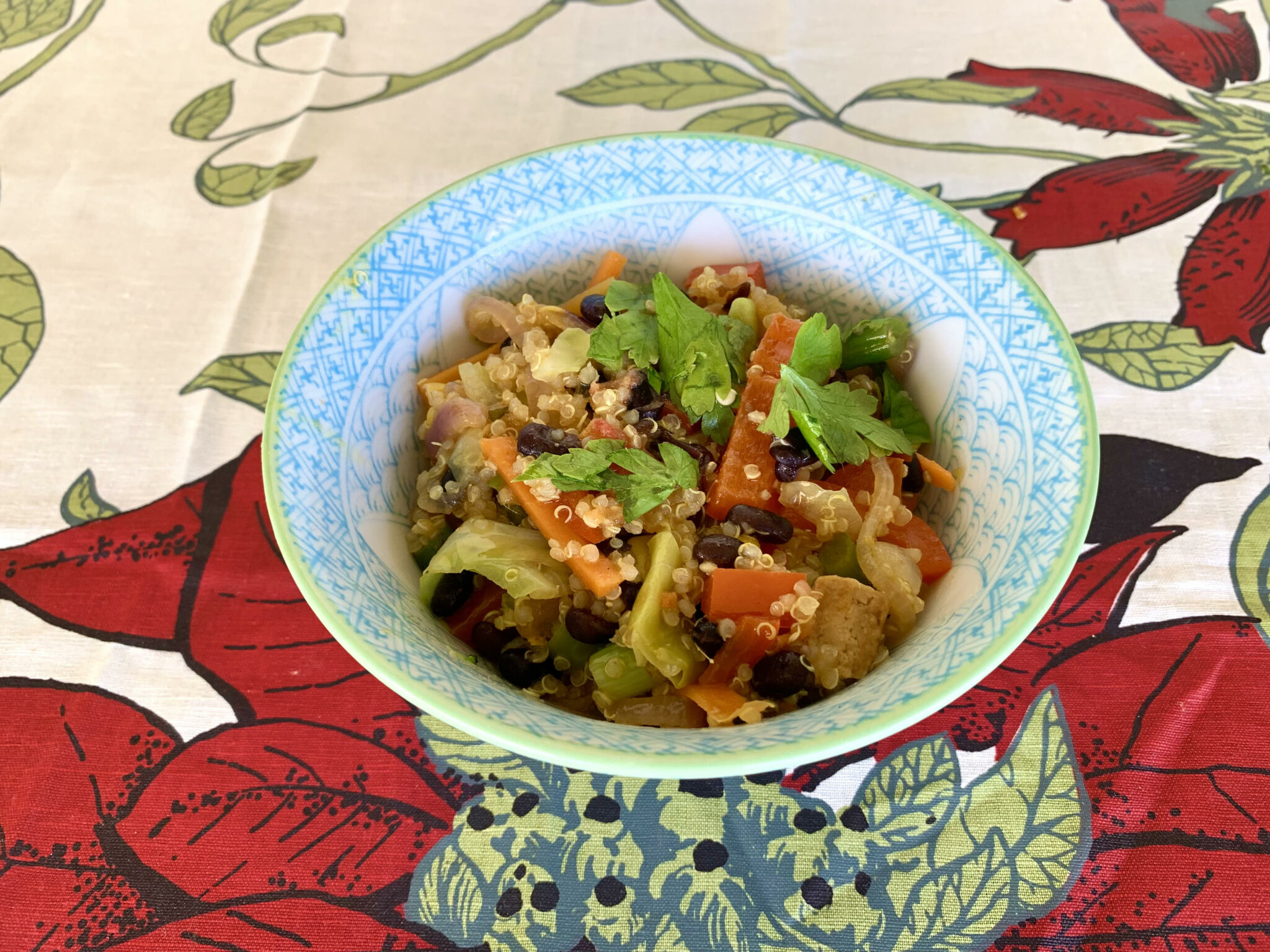 Bowl of quinoa fried rice with black beans, tofu and stir fried vegetables