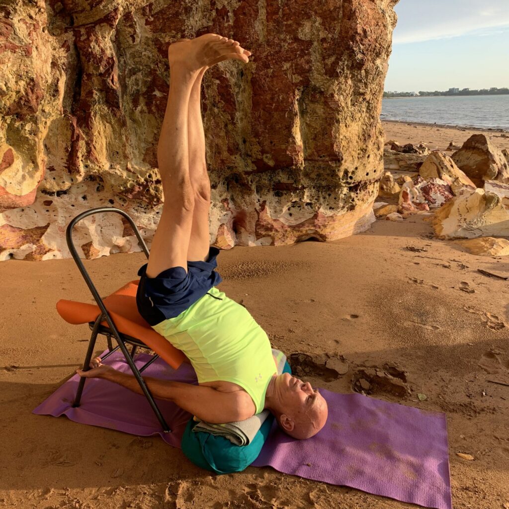 Stuart in supported shoulder stand with a chair