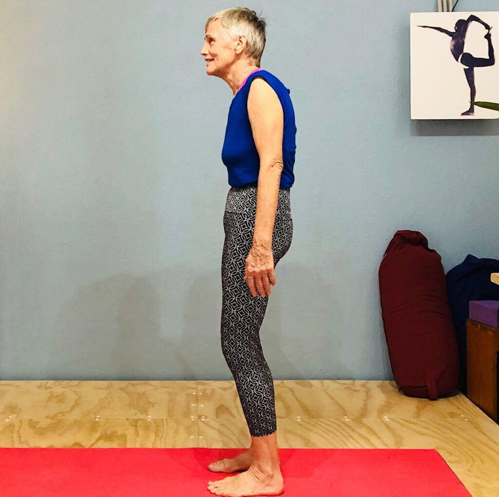 Bad posture: a woman standing side on with the head and shoulders drifting forward