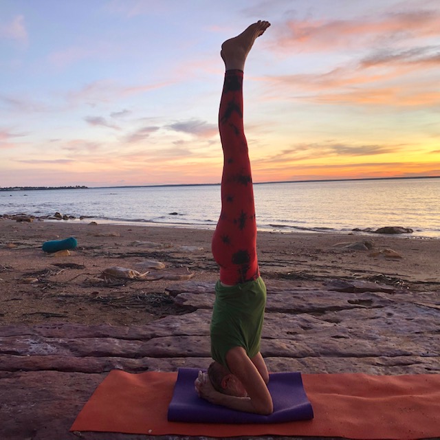 Chris Lalor in Headstand on a Darwin beach at sunset, legs straight and together