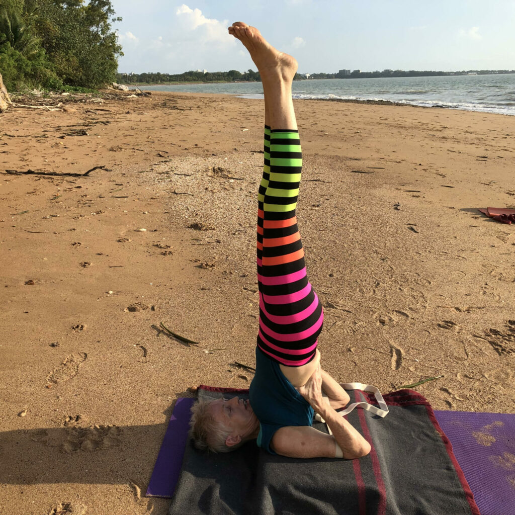Chris in shoulder stand on the beach