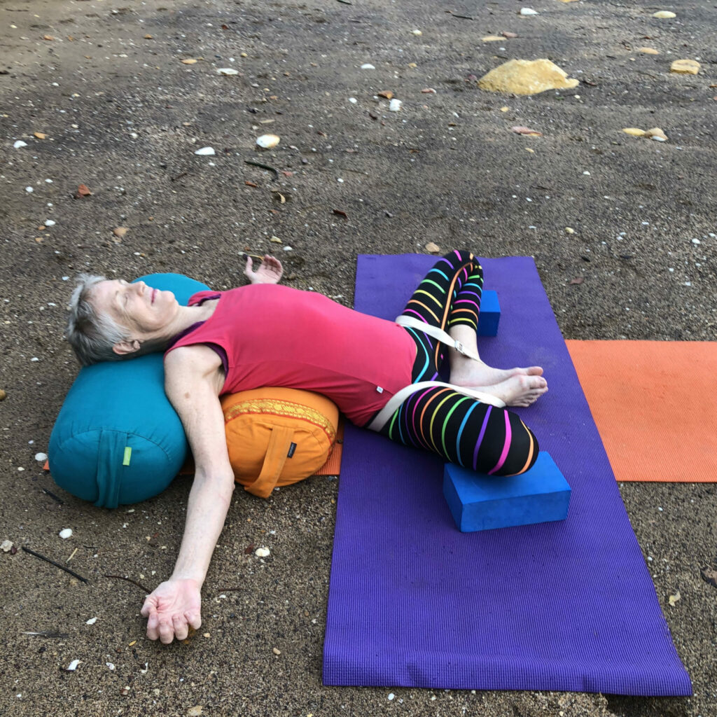Chris lying over bolsters with the legs supported on a block
