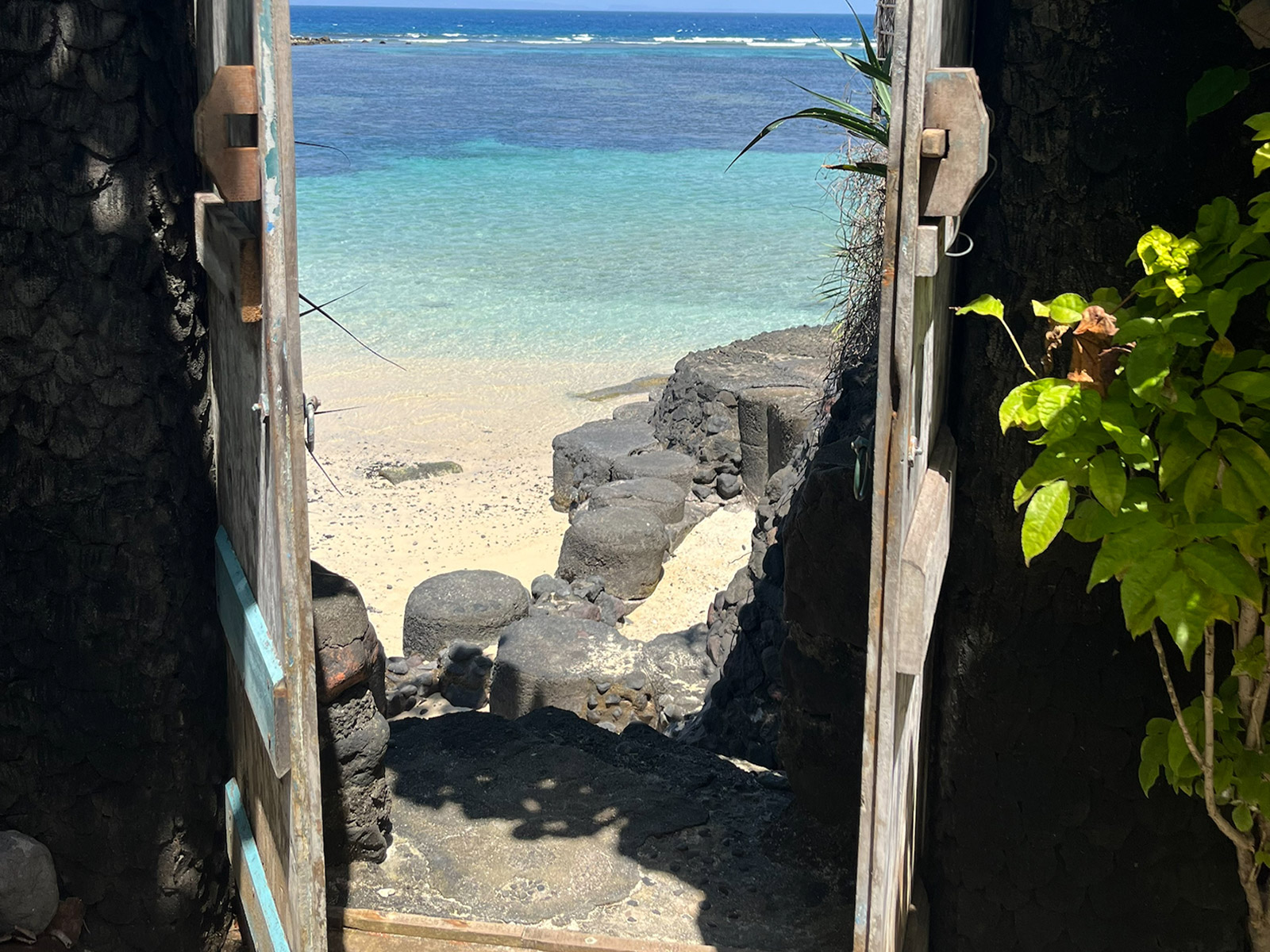 Looking out through a stone gateway to the beach and sea at Candidasa, East Bali