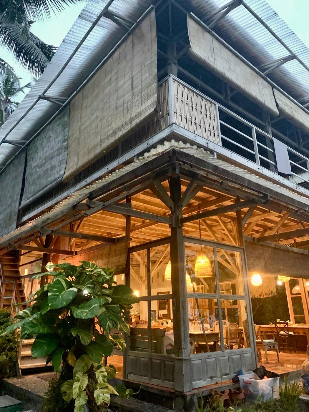 The dining room and the upstairs yoga room at Pondok Pisang, Candidasa, lit at dusk