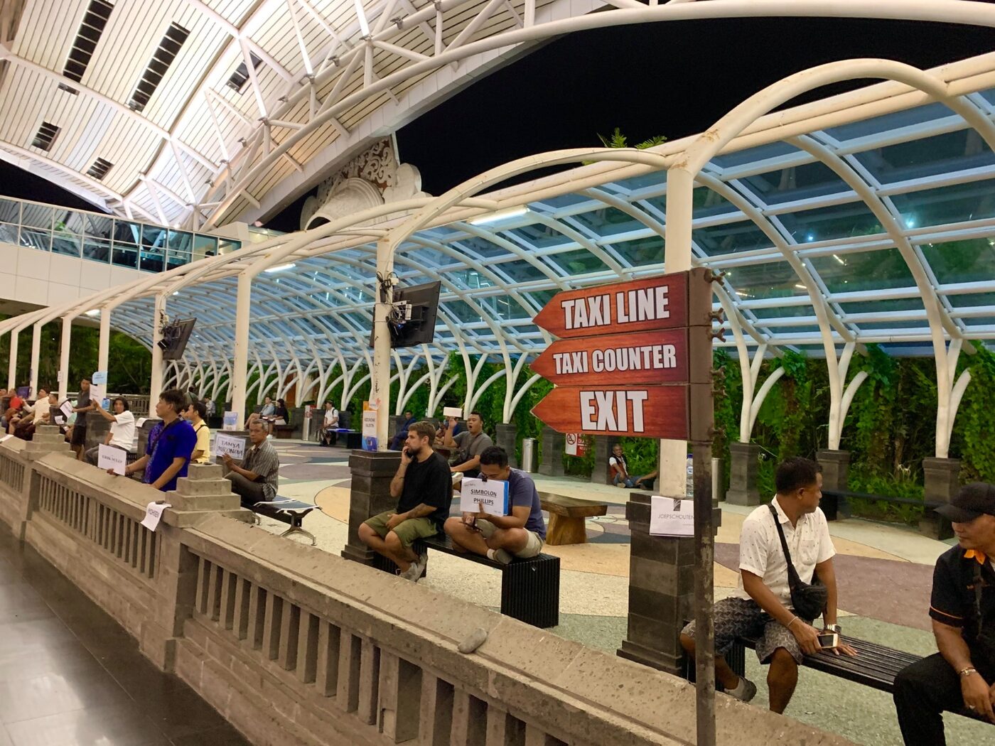 The taxi driver waiting area outside the arrivals exit at Denpasar airport, Bali