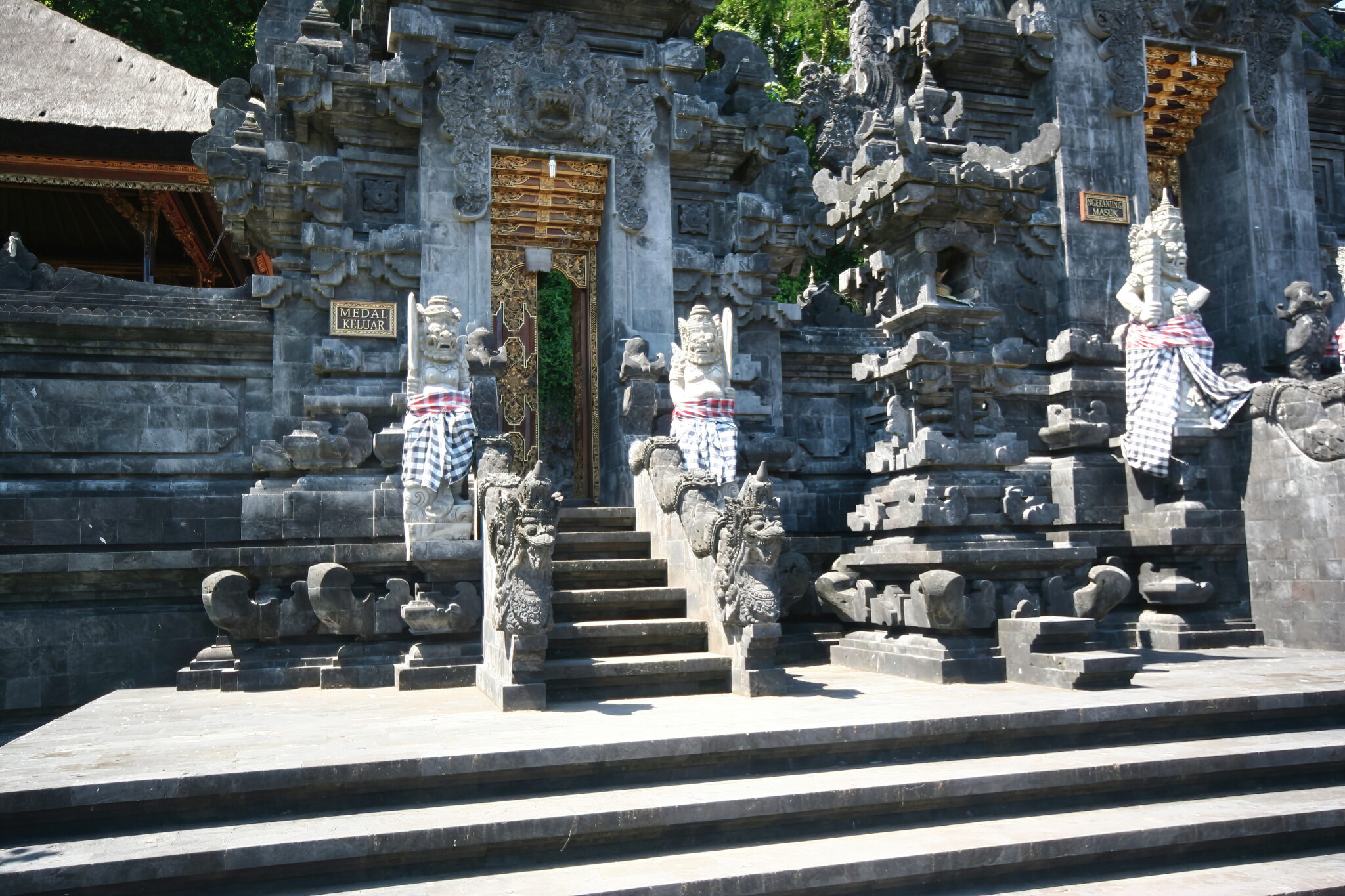 The carved gateway and guardian statues at Pura Goa Lawah, the bat cave temple on the coast road west of Candidasa