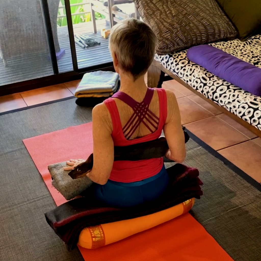 Is pranayama safe? Chris Lalor practising seated pranayama on a bolster at Flametree Yoga Studio, Darwin