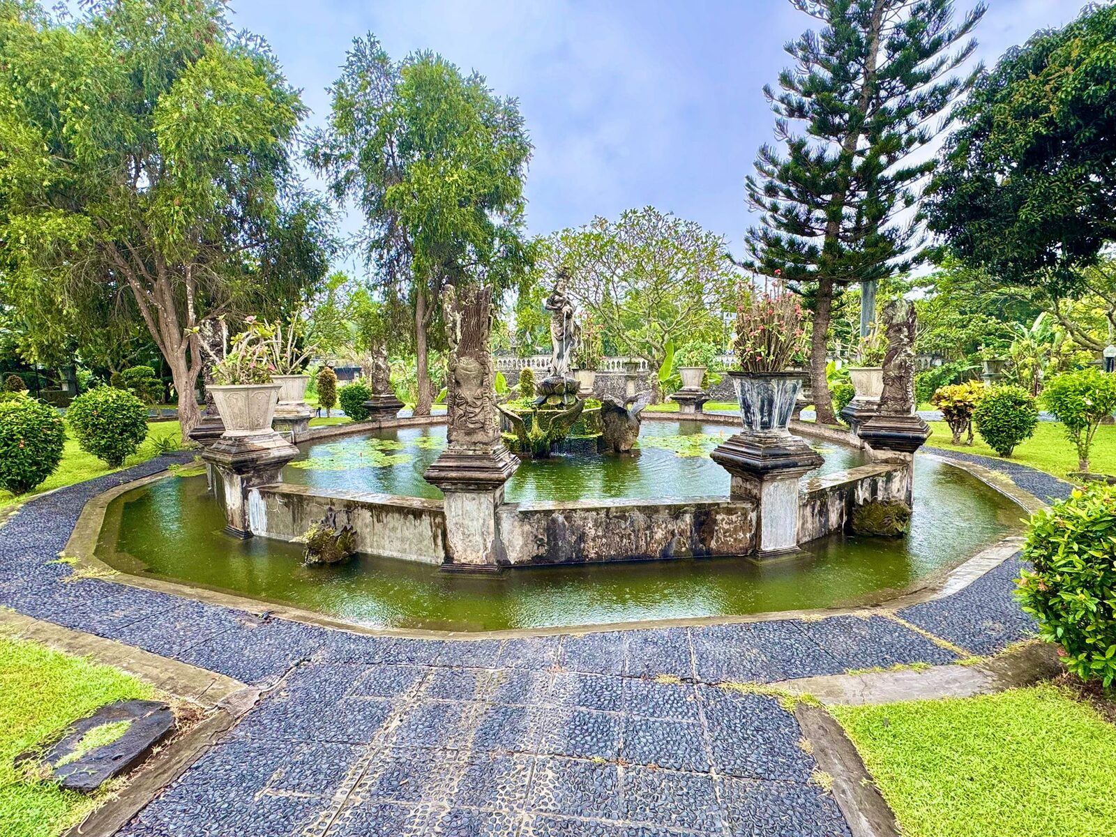 A large tiered stone fountain in a formal pool in the water palace gardens of East Bali