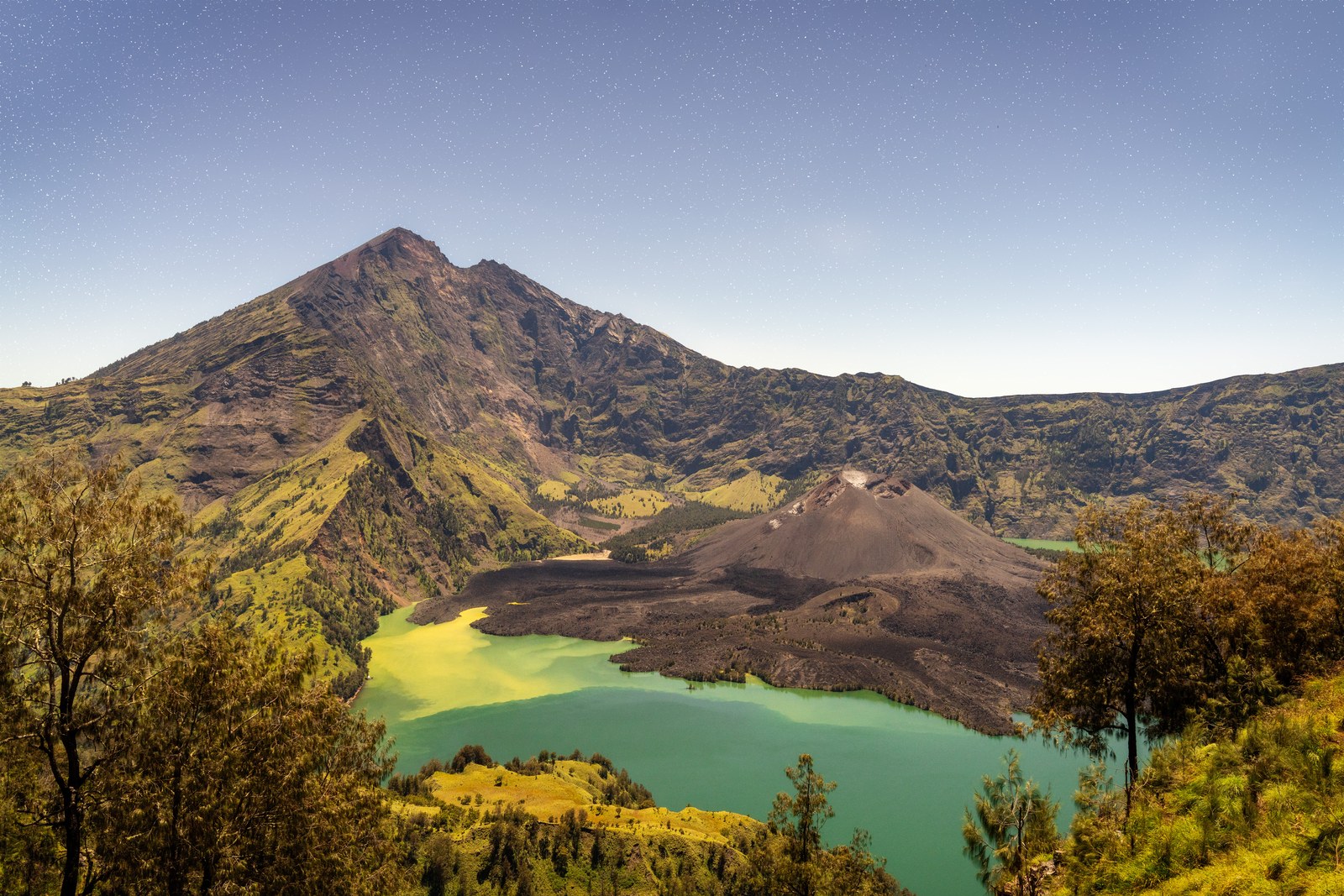 The summit of Mount Rinjani on Lombok above the green Segara Anak crater lake and the young volcanic cone inside the caldera