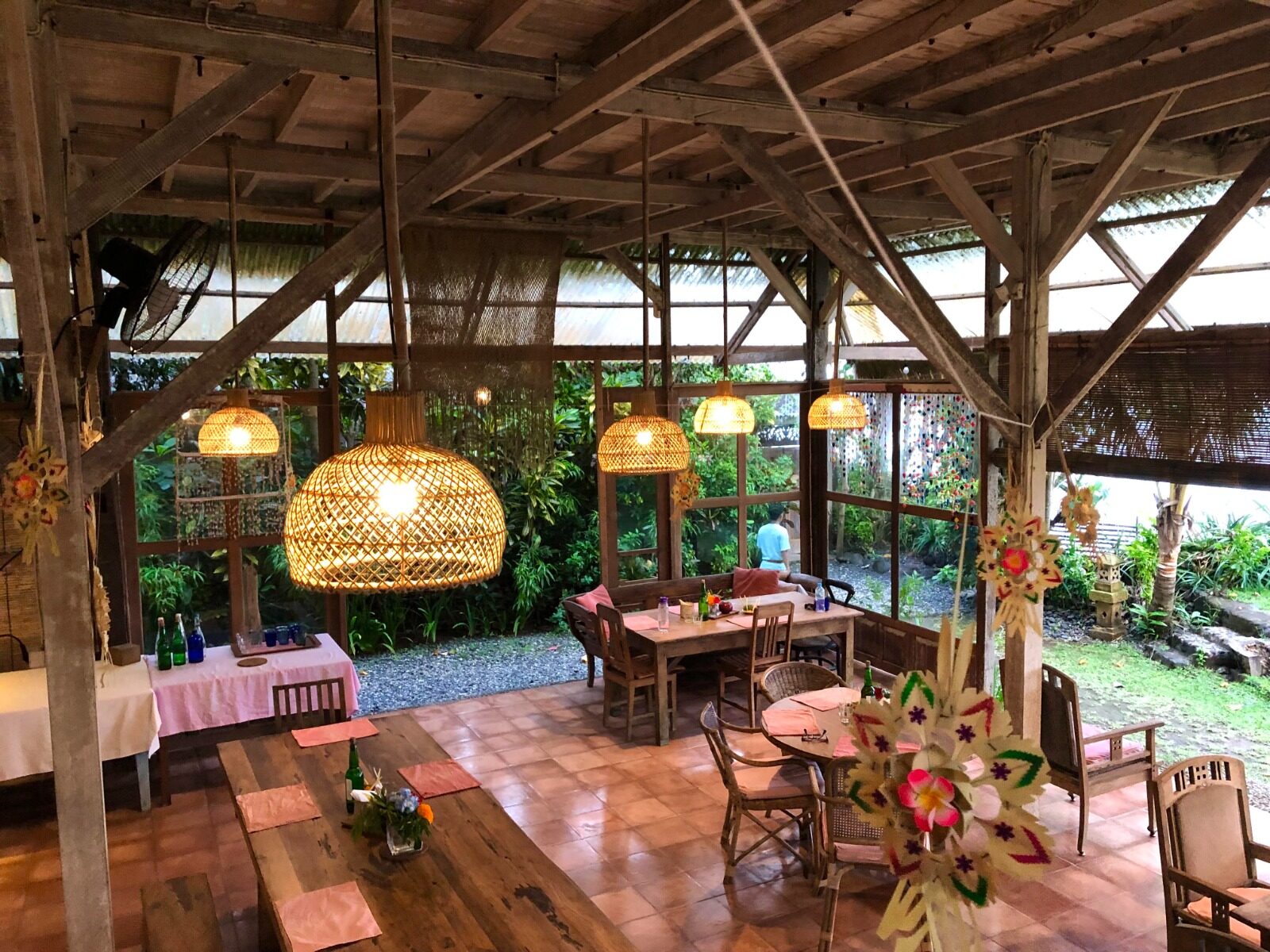 The open dining room at Pondok Pisang lit with lanterns in the evening, Candidasa, Bali