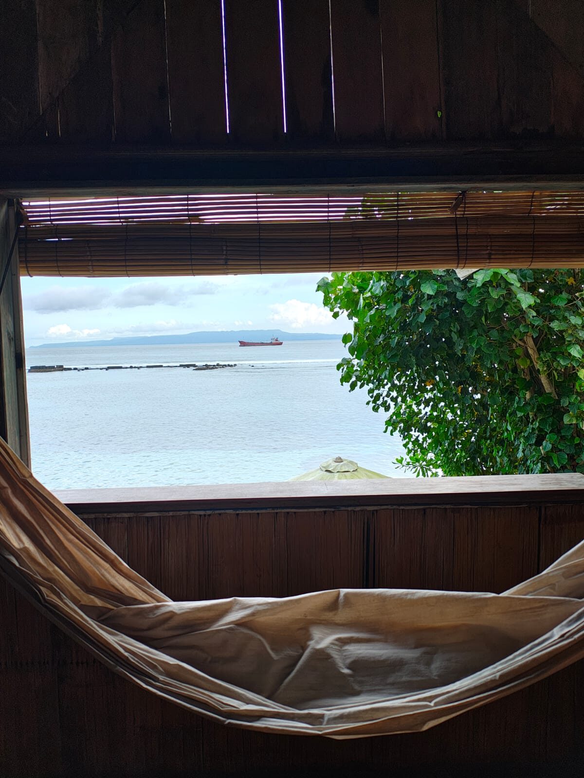 A hammock strung on a balcony looking out over the sea at Pondok Pisang, Bali