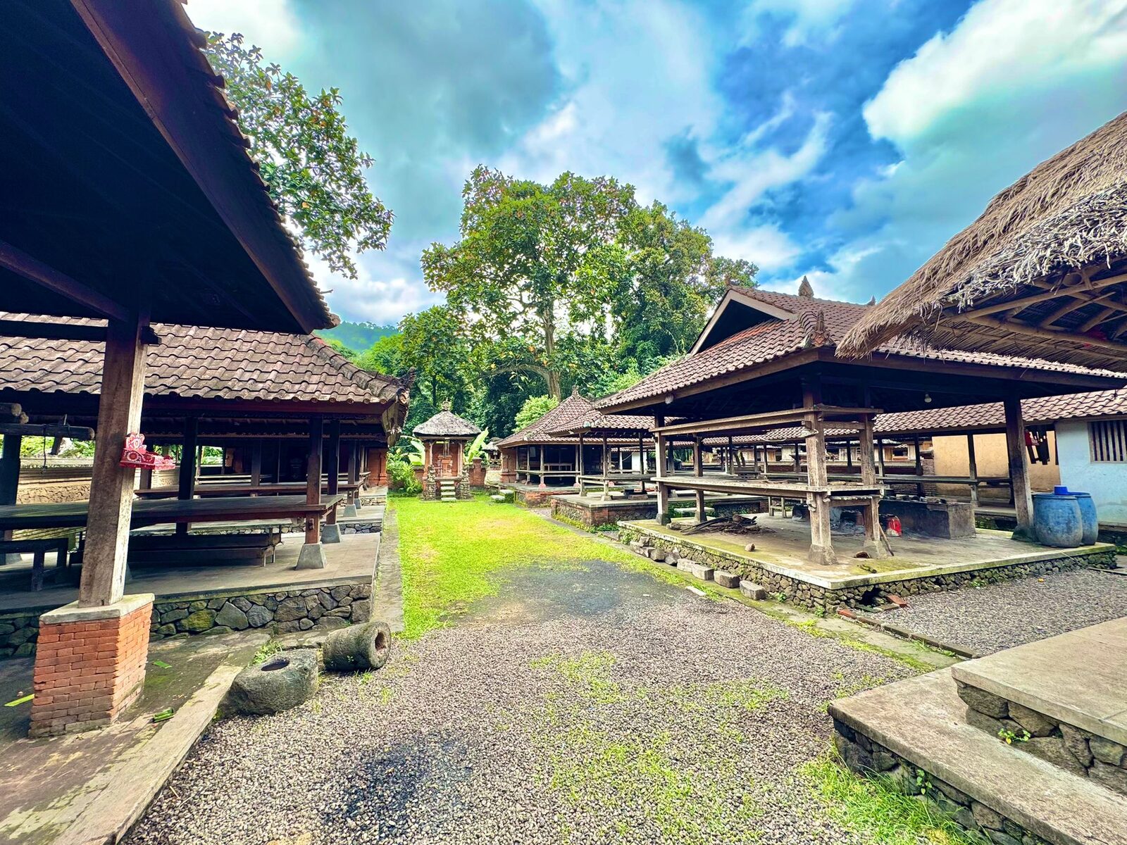 Open thatched pavilions along the grass avenue in Tenganan village, Bali