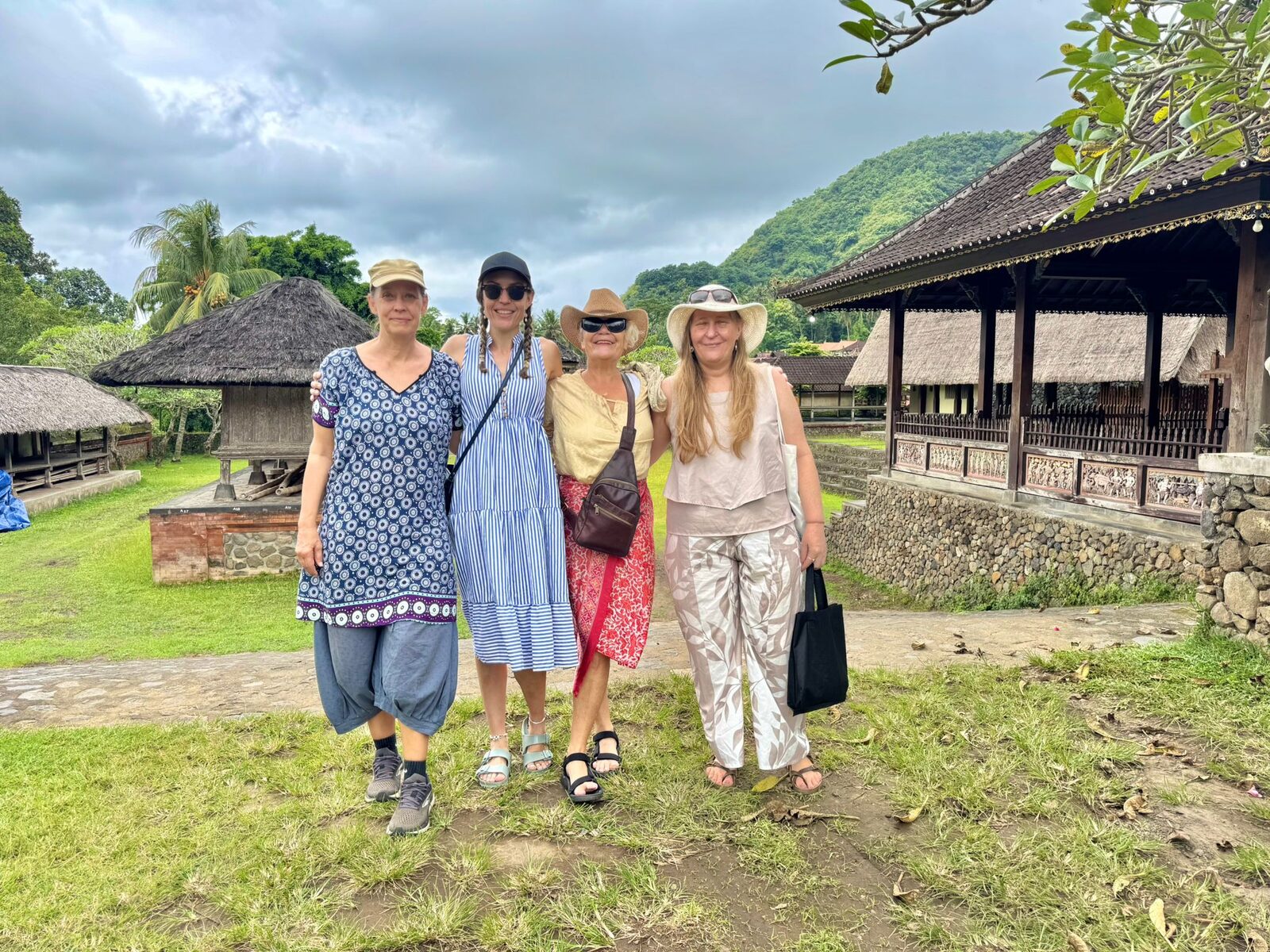 Four Flametree retreat guests walking through Tenganan village with the hills behind