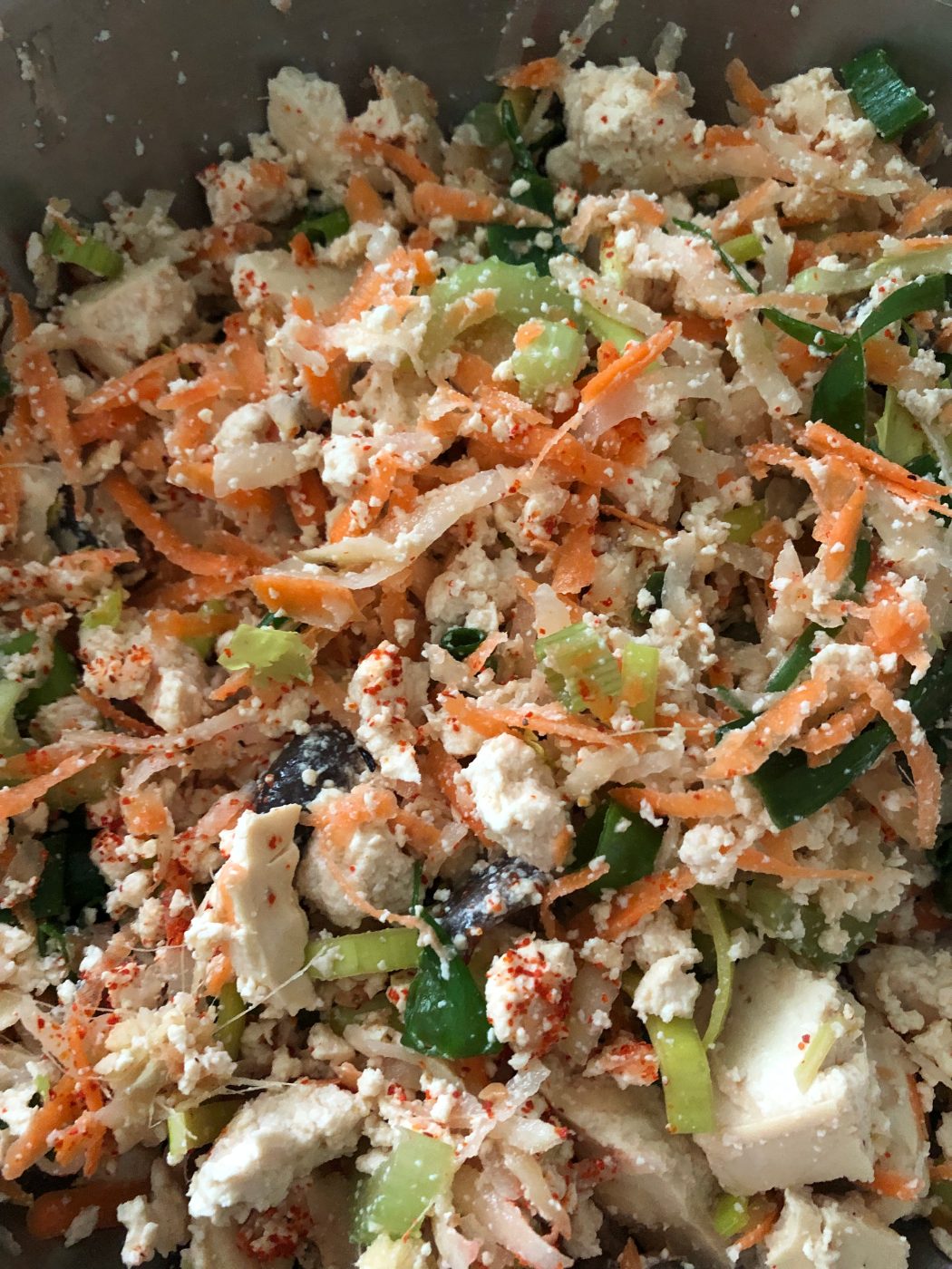 Gluten free wonton filling of crumbled tofu, grated carrot, celery, shiitake and spring onion