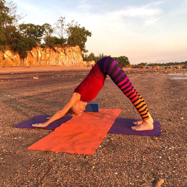 How to reduce dementia risk: Chris Lalor in Downward Facing Dog on a rock platform at sunset