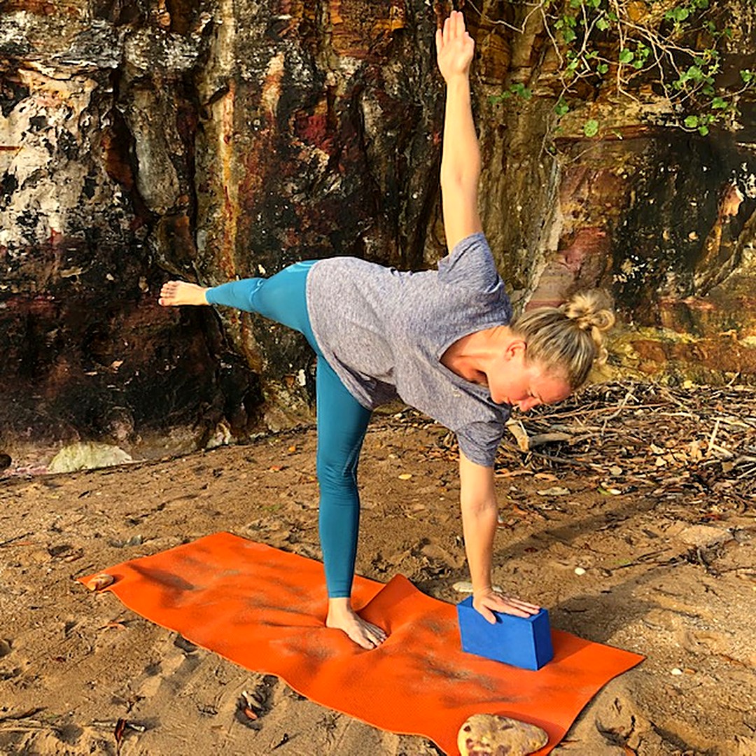 Menopause belly and yoga: Kim in Half Moon Pose, Ardha Chandrasana, with her lower hand on a block