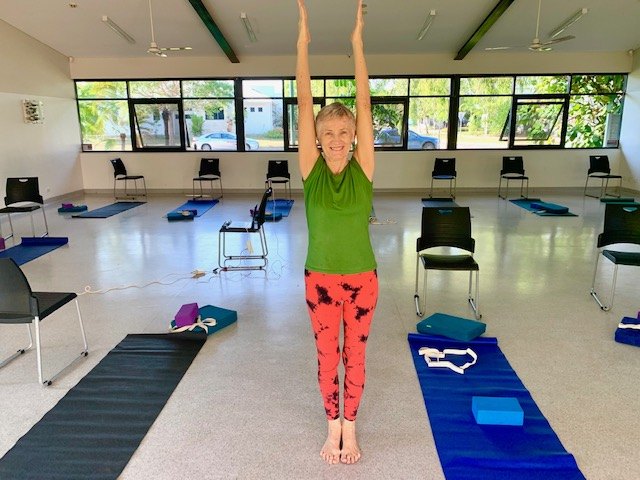 Iyengar yoga teaching at Flametree: Chris Lalor smiling with arms raised in the Casuarina hall, Darwin