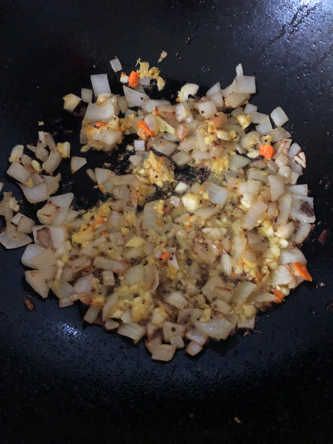 Onion, garlic, ginger and mustard seeds cooking in oil for a jackfruit curry