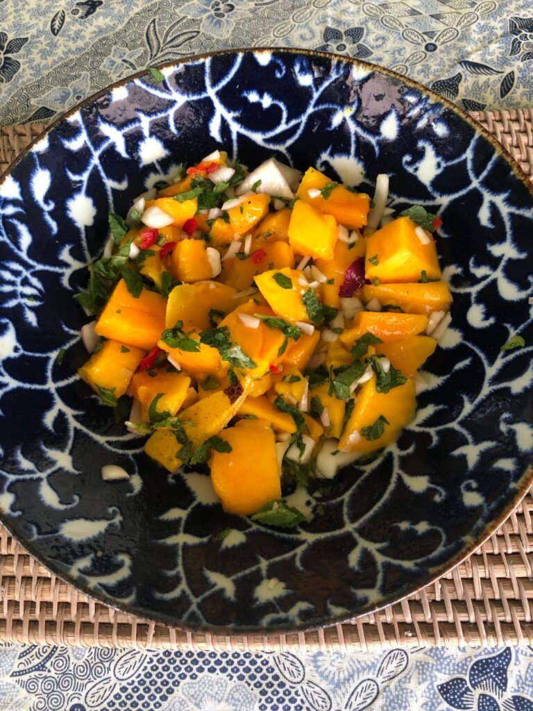 Mango salsa with mint, red onion and chilli in a blue and white patterned bowl