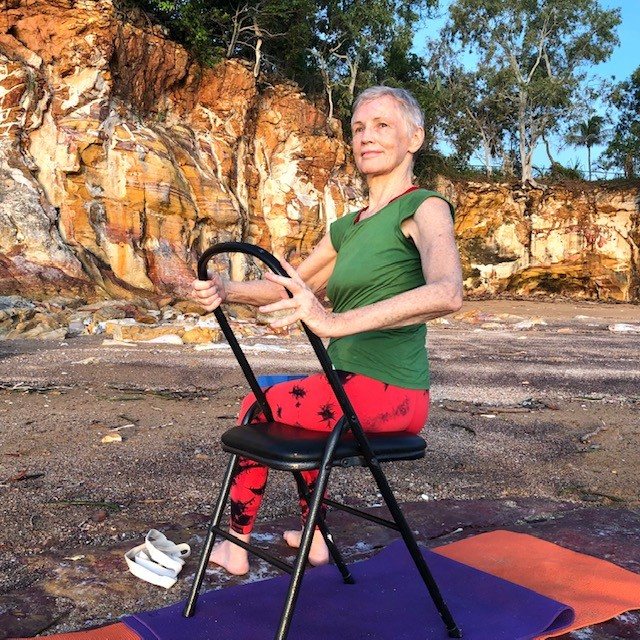 Mid back pain: Chris Lalor in a gentle seated twist on a chair, chest lifted, turning from the middle and upper back