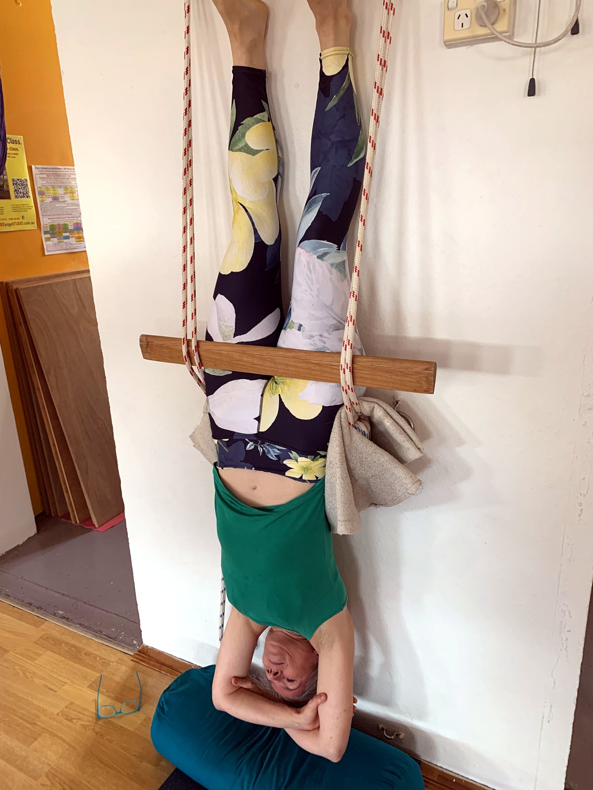 Gertie in a rope yoga headstand with legs straight and the ropes taking the weight