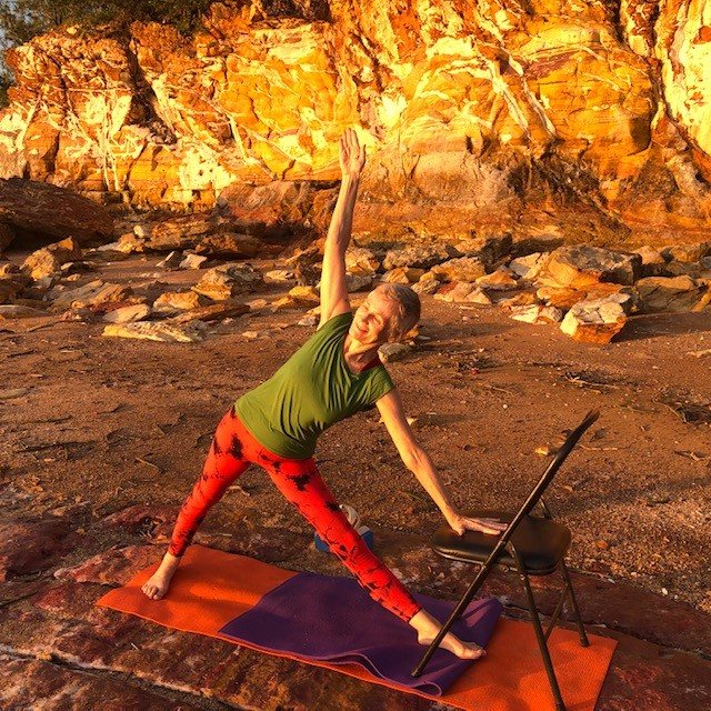 Yoga for flexibility: Chris Lalor in Triangle Pose on a rock ledge at sunset, both legs straight